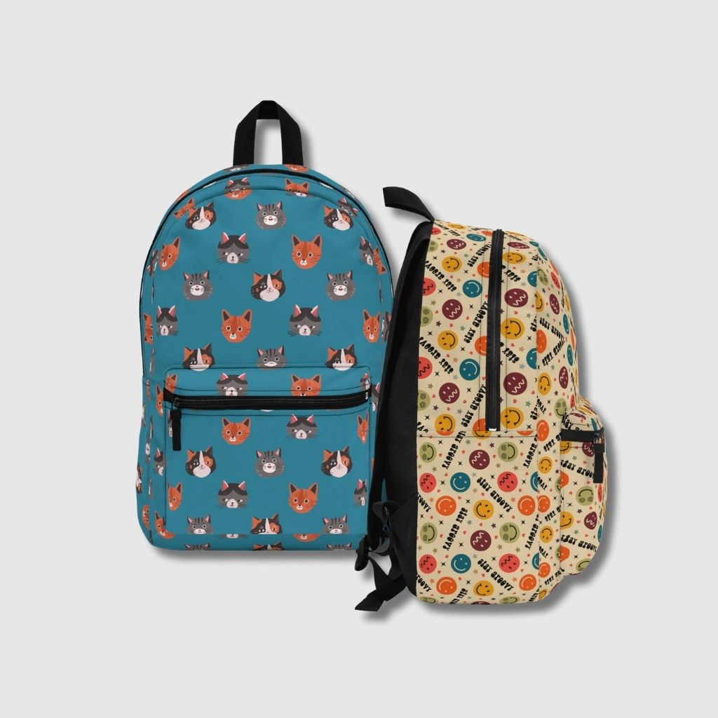 Two backpacks - blue backpack with cute cat heads and Stay Groovy backpack with Emoji faces