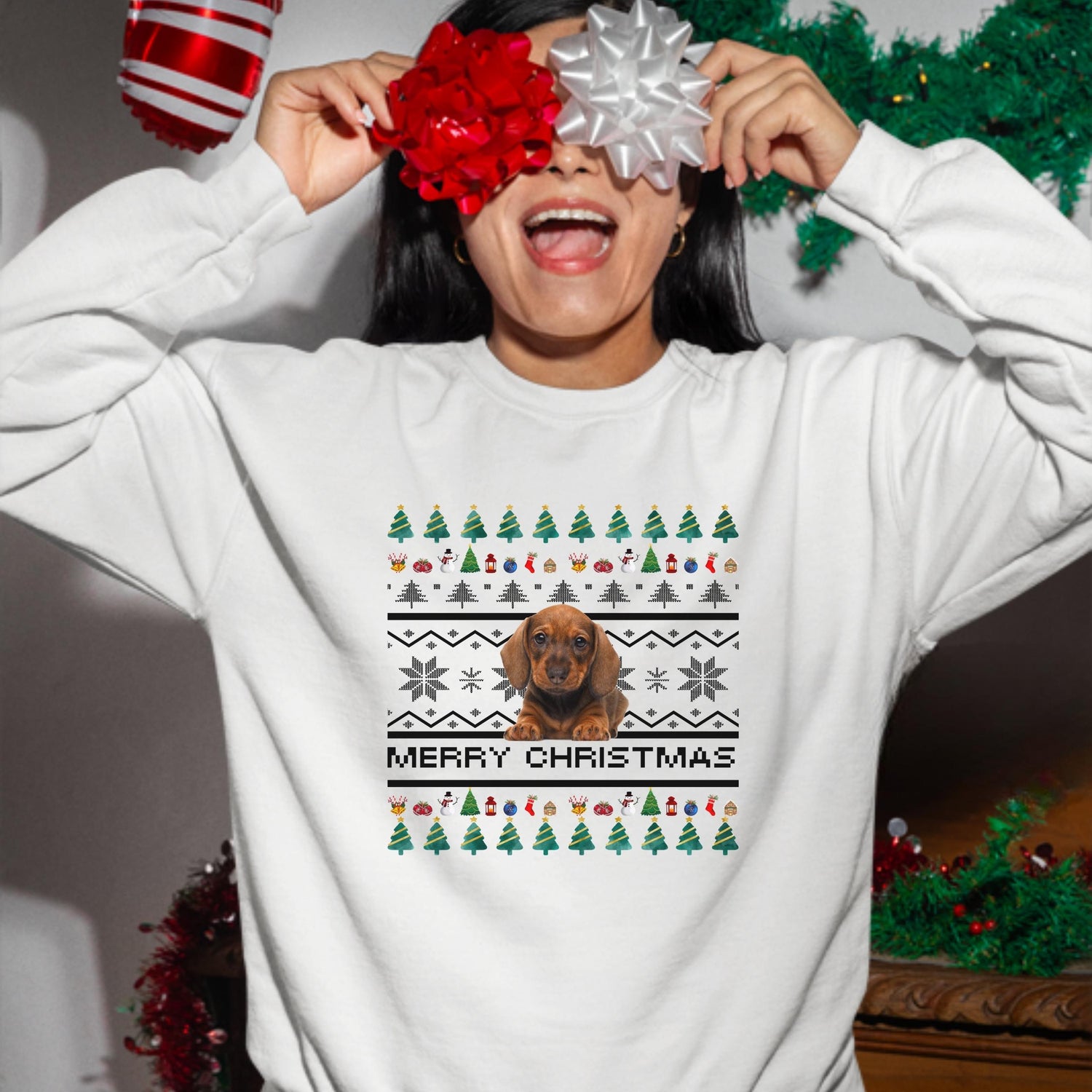 A woman wearing a white christmas style sweatshirt in a joyful mood.